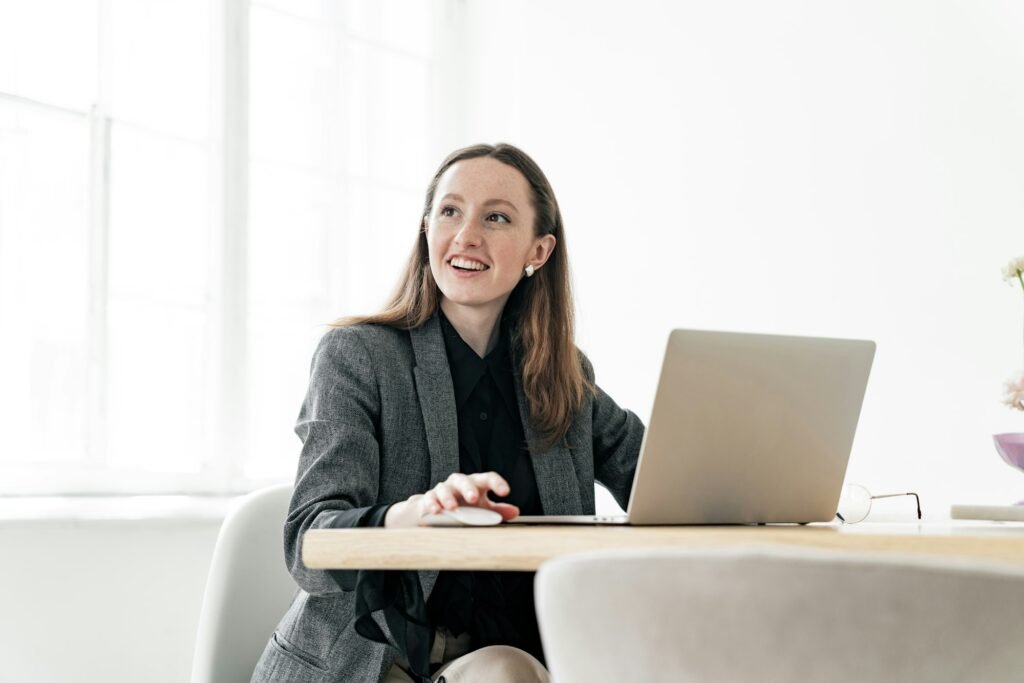 young female financier uses a laptop in formal attire. An online website for analytics